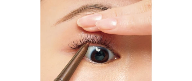 利き手と逆の指で上まぶたを引き上げ、極細のアイライナーを下から差し込むようにしながら、まつ毛の間を色で埋めて。