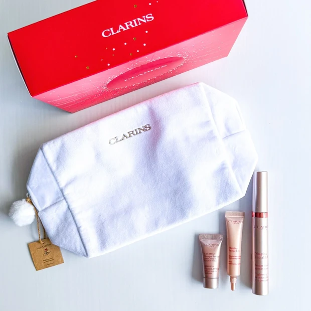 クラランス V コントア ホリデーセット 2025の全体写真。目元美容液（グラン アイ セラム V）現品と、フェイスライン美容液、クリームマスク、白い限定ポーチが並んでいる様子。