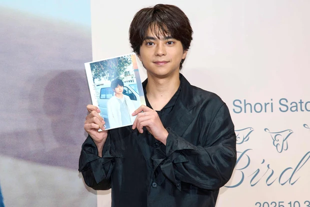 登場後、緊張した面持ちで静止画、動画撮影に応じるtimelesz 佐藤勝利さん。写真集を持ってニッコリ。