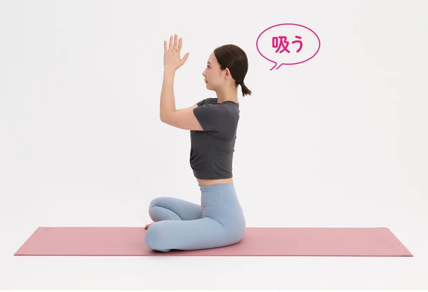 床にあぐらをかいて座り、両腕のヒジを合わせて、息を吸いながらヒジを胸の高さに上げる。