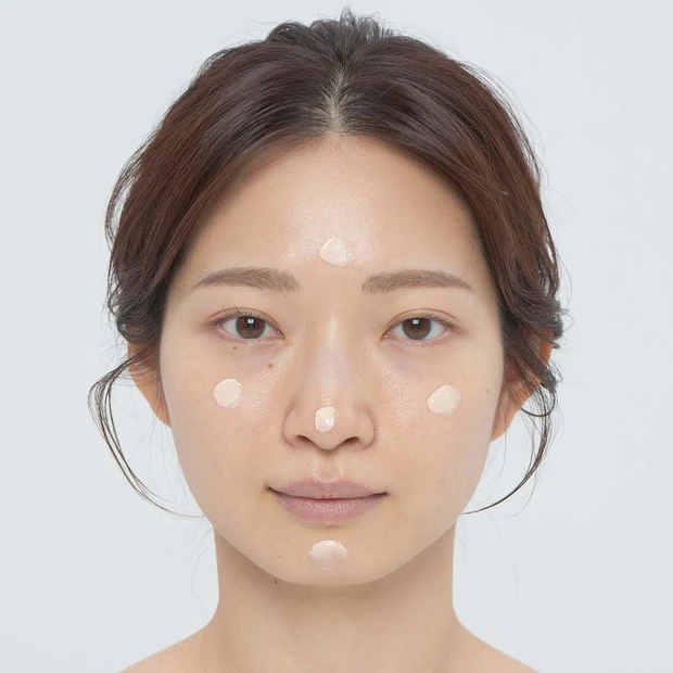 1.大事なのは潤い。潤い力のある高保湿の下地を顔全体にまんべんなくひろげるため、両頬、おでこ、あご、鼻先の5点にのせる。