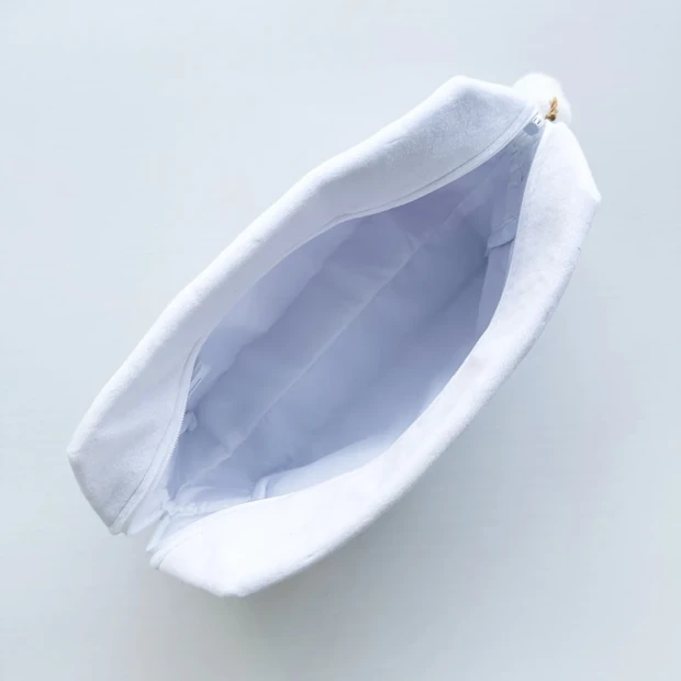 限定オリジナルポーチのチャックを開け、中が見える状態の写真。裏地の色や収納力がわかる。