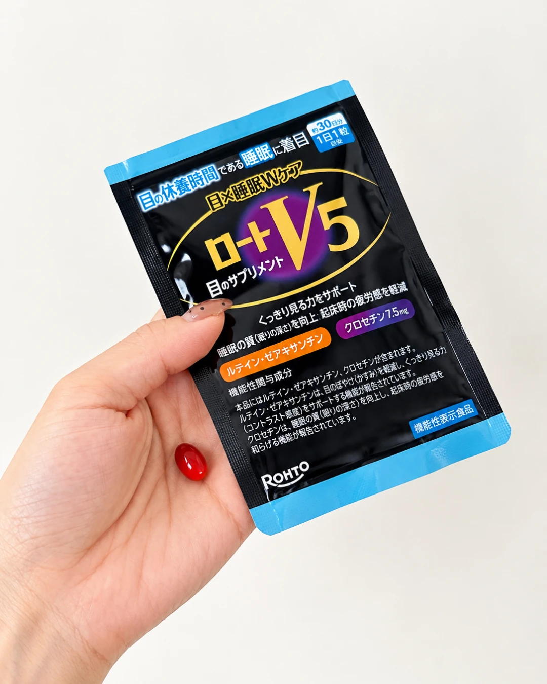 ロート製薬「ロートV5 目×睡眠Wケア」の商品パッケージを手に持った写真。目の休養時間である睡眠に着目し、ルテイン・ゼアキサンチン・クロセチンを配合した機能性表示食品。