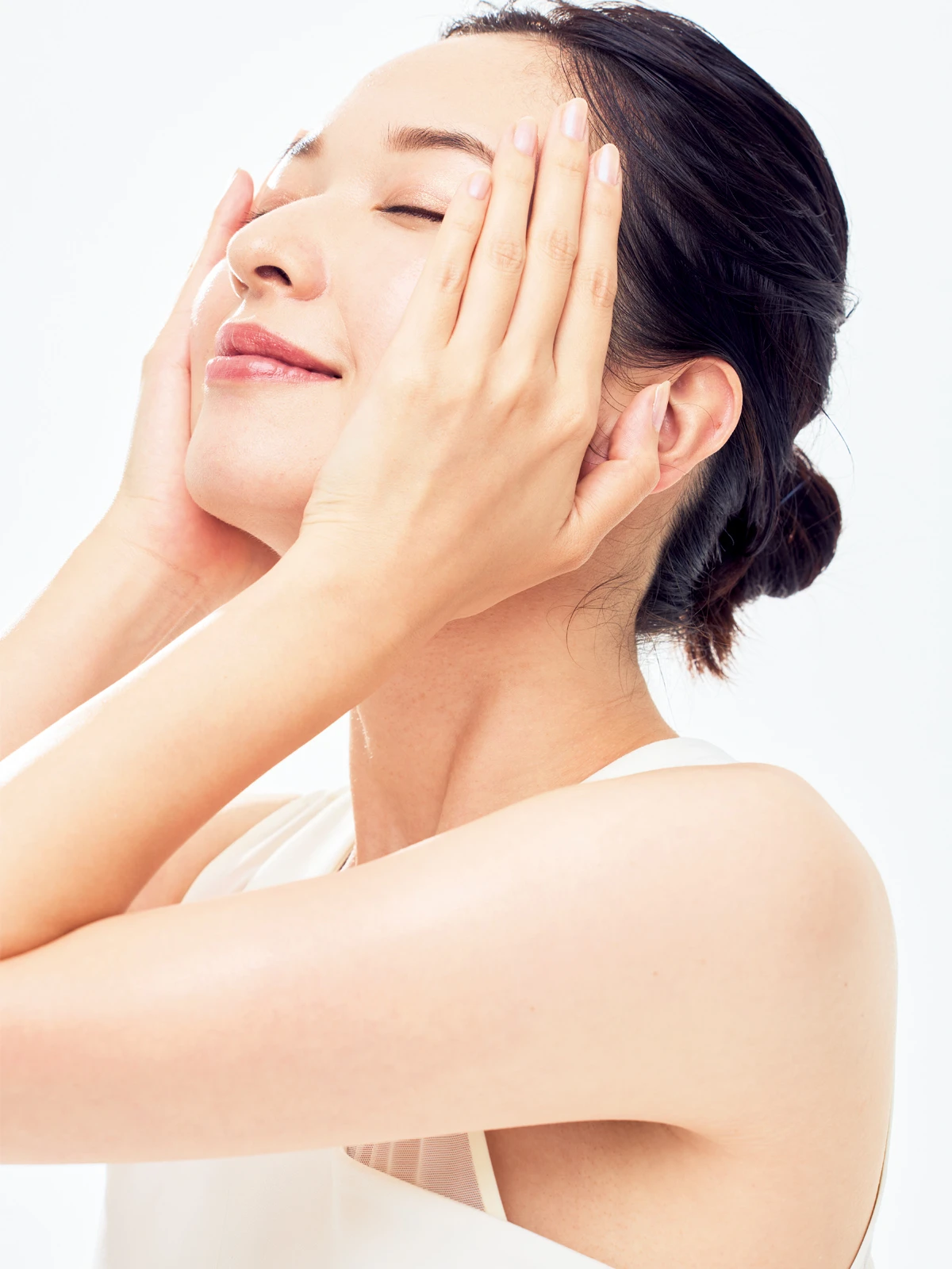 ①顔をやや上に向けて目を閉じ、美容液を伸ばした手のひらで包みこんでハンドプレス。