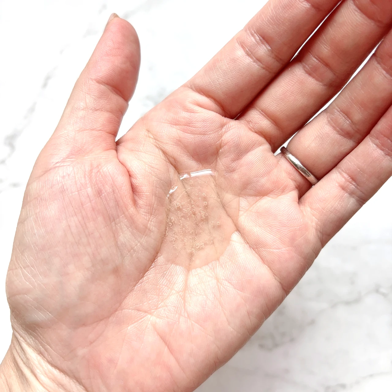 髪のツヤと潤いを与えるインシルク ブースターシャンプーを手に取った写真