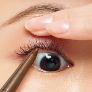 利き手と逆の指で上まぶたを引き上げ、極細のアイライナーを下から差し込むようにしながら、まつ毛の間を色で埋めて。